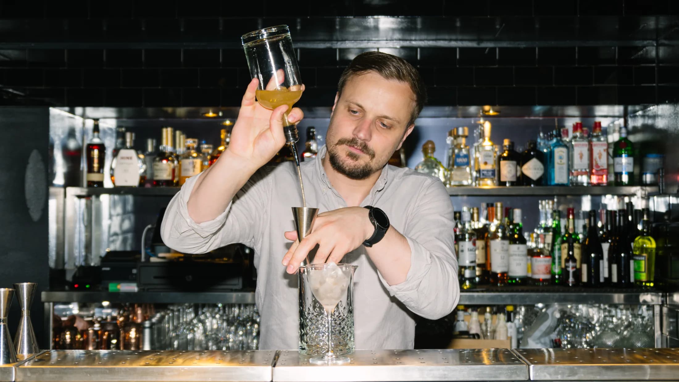 ZIMA bartender mixing a cocktail behind the bar