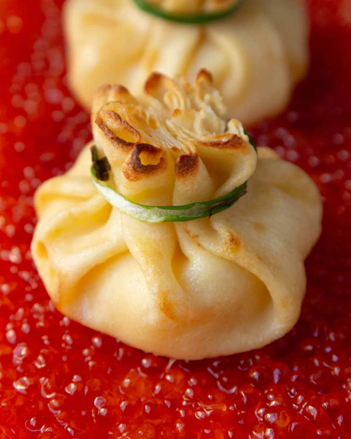 Dumplings served over a bed of red caviar