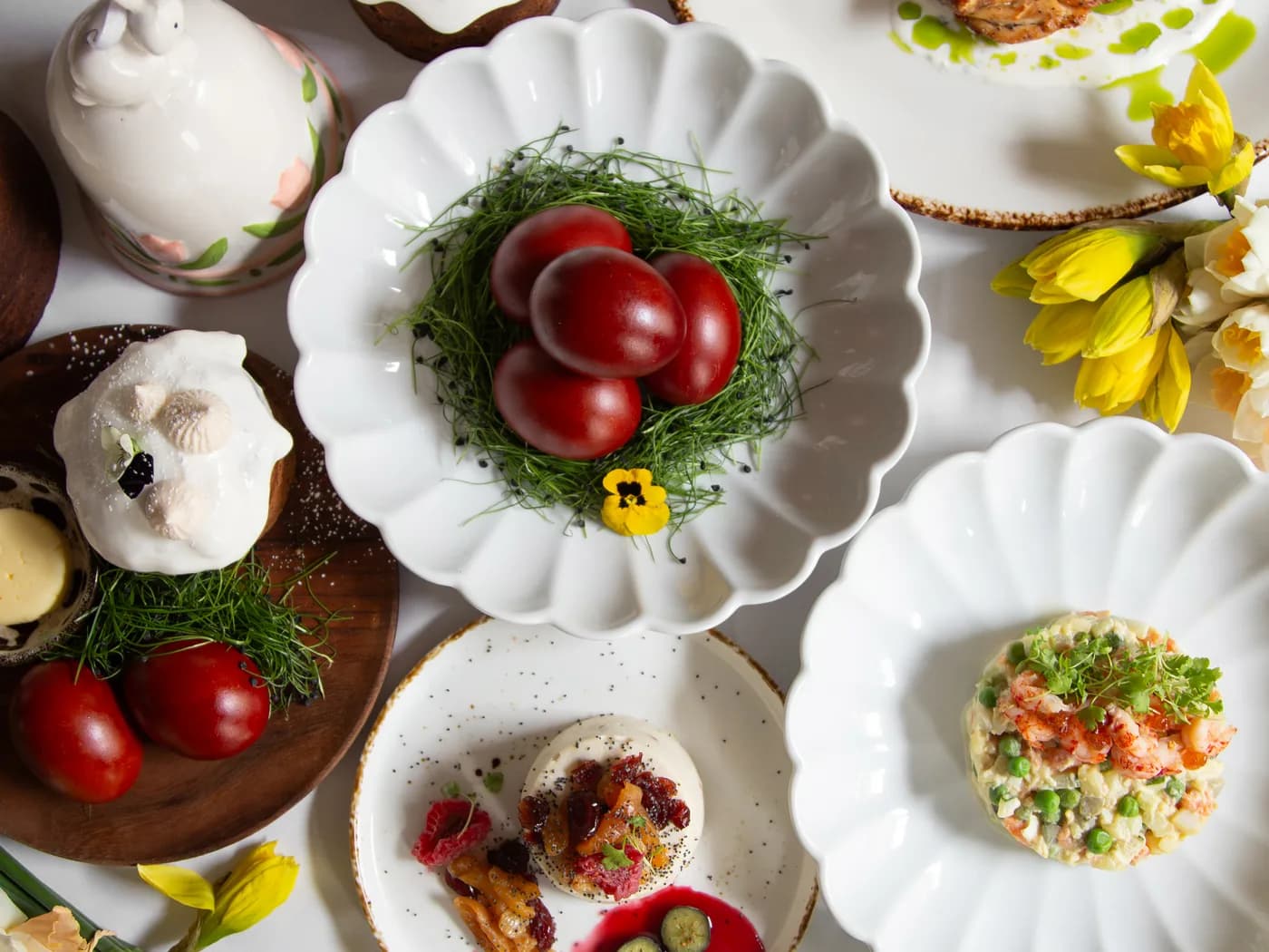 Easter table with painted eggs, paskha and spring flowers