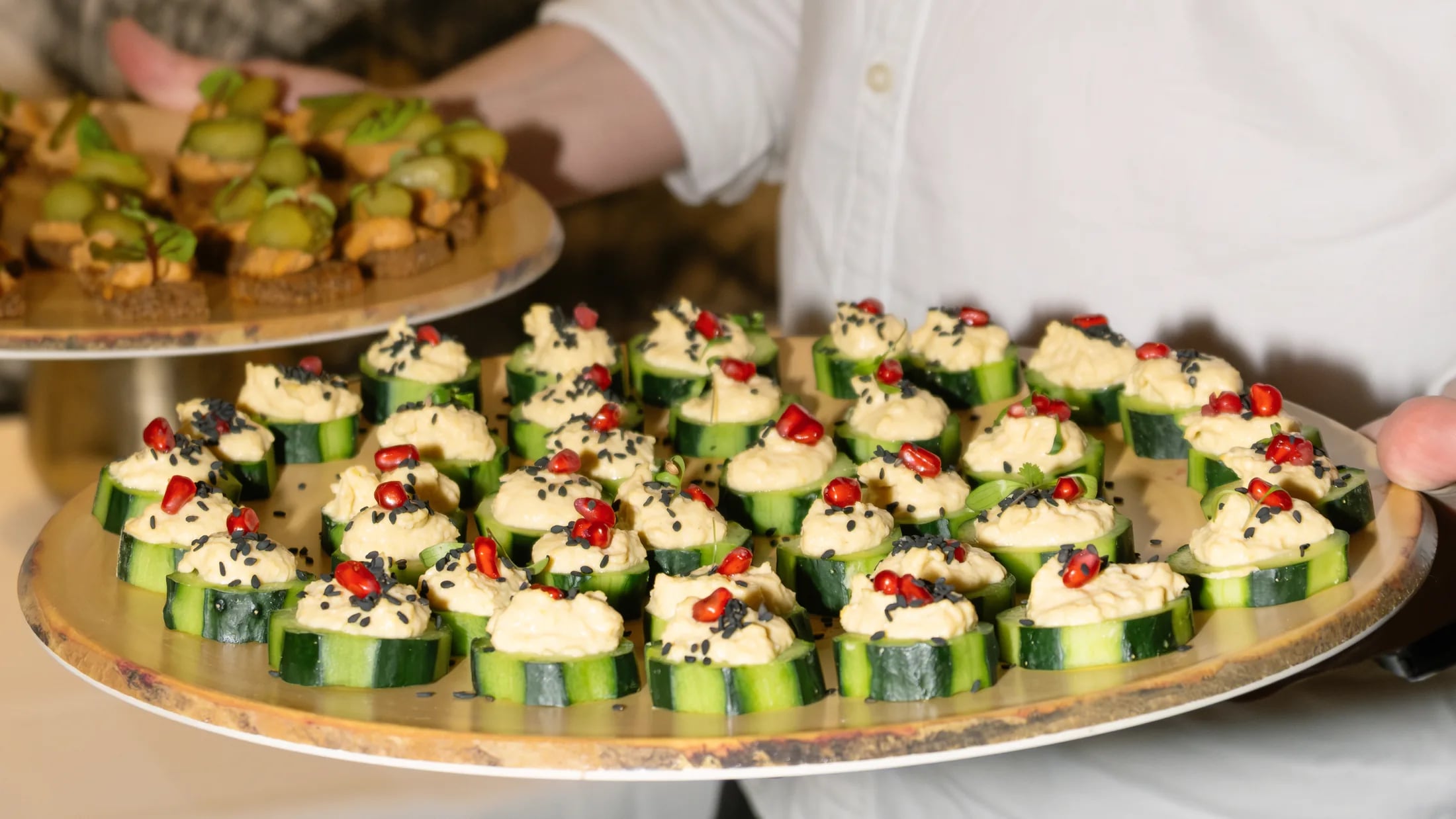 Waiter carrying a tray of ZIMA canapés at a private event